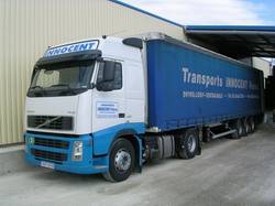 Camion de l’entreprise : cabine blanche et bleue, semi-remorque à bâche bleue